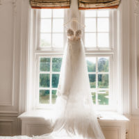 Hanging wedding bridal dress on the window. Morning of the bride and wedding photoshoot in the Netherlands.