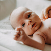 Newborn baby lying on a changing table during a lifestyle newborn photoshoot in Amsterdam by a professional photographer