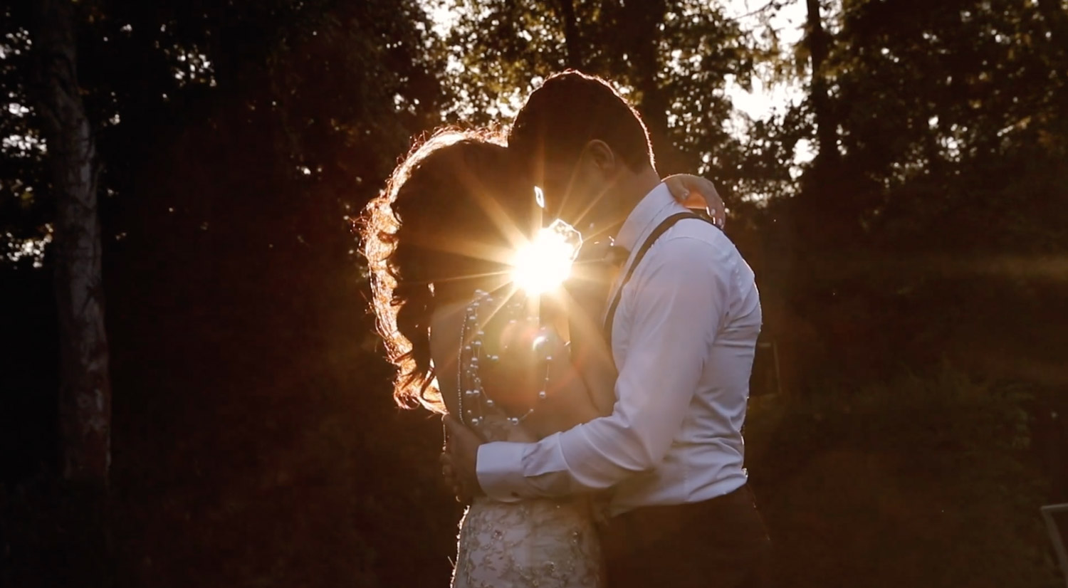 Man and woman are hugging each other in sunset rays while videograaf nederland makes a film