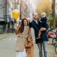 Family with two children holding balloons during a family photoshoot in Amsterdam by a professional photographer