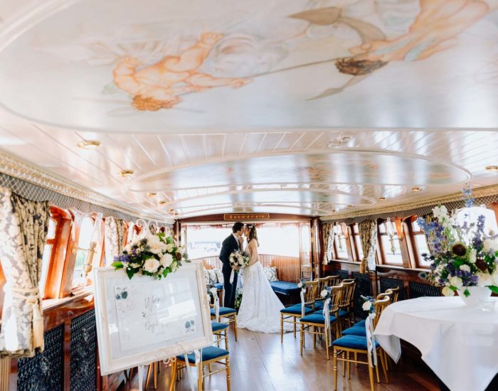 Nautical wedding on the boat in Amsterdam, authentic interior with the wedding couple in the background
