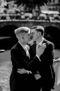 Gay couple at the gay wedding photoshoot kissing each other. Black and white photo