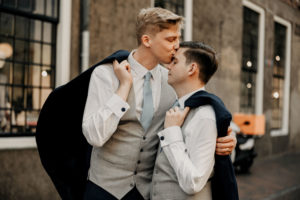 Gay wedding photoshoot in Netherlands Amsterdam and Utrecht. Gay couple kiss each other gently, posing to photographer in Utrecht,