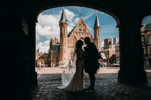 Trouwen in Den Haag. Trouwfotografie Den Haag. Wedding photographer in Den Haag took a picture in Binnenhof The Hague. On the photo couple stands in front of Ridderzaal