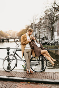 Photographer in Amsterdam captures a couple on a bicycle seating and smiling to each other
