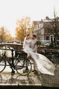 Beautiful wedding photoshoot in Amsterdam where couple is on the bridge with a sunset on background