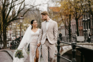 Couple is walking down the street during a wedding photoshoot in Amsterdam