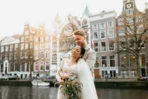 wedding photoshoot in Amsterdam where a couple smiles and enjoys with a view on canal