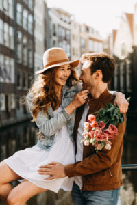 Expertly captured by their talented couple photographer in Amsterdam, this happy couple photoshoot in Amsterdam beautifully captures the romance and magic of the city. The girl is smiling and touching the face of her boyfriend.