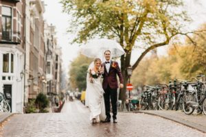 Couple walking down the street during their wedding photoshoot in Amsterdam. We can help you getting married in Amsterdam