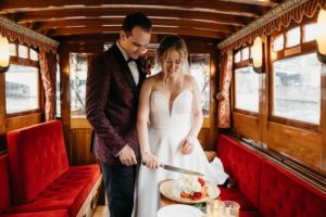 Couple getting married in Amsterdam on the boat and cutting cake