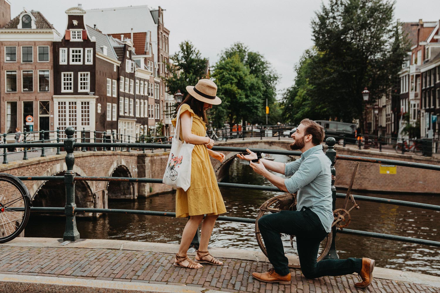 Guy proposes to a girl on the bridge of Amsterdam. Photographer makes photo. He choose Amsterdam proposal package to capture the best moment.
