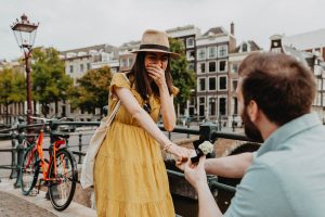 Girl is surprised and closes her mouth after she was proposed in Amsterdam. Her fiancé used Amsterdam proposal packages that offer best options to reminder this day forever.