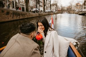 boat proposal in Amsterdam. On the photo a guy proposes to a girl on the boat during photoshoot in Amsterdam