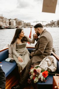 Romantic couple on the boat, the guy kisses her hand when he did a boat proposal in Amsterdam