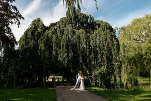 Photoshoot in Kasteel de Haar. Wedding couple stays in front of huge tree