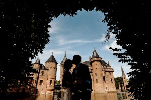 Silhouette photo where couple stays in front of the castle. Trowen in Kasteel de Haar of fotoshoot in Kasteel de Haar - is de mooiste trouwlocatie in Nederland.